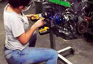 Mujer Haciendo Labores de Mantenimiento al Motor